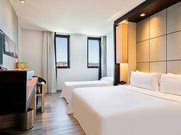 a room with two beds and a piano