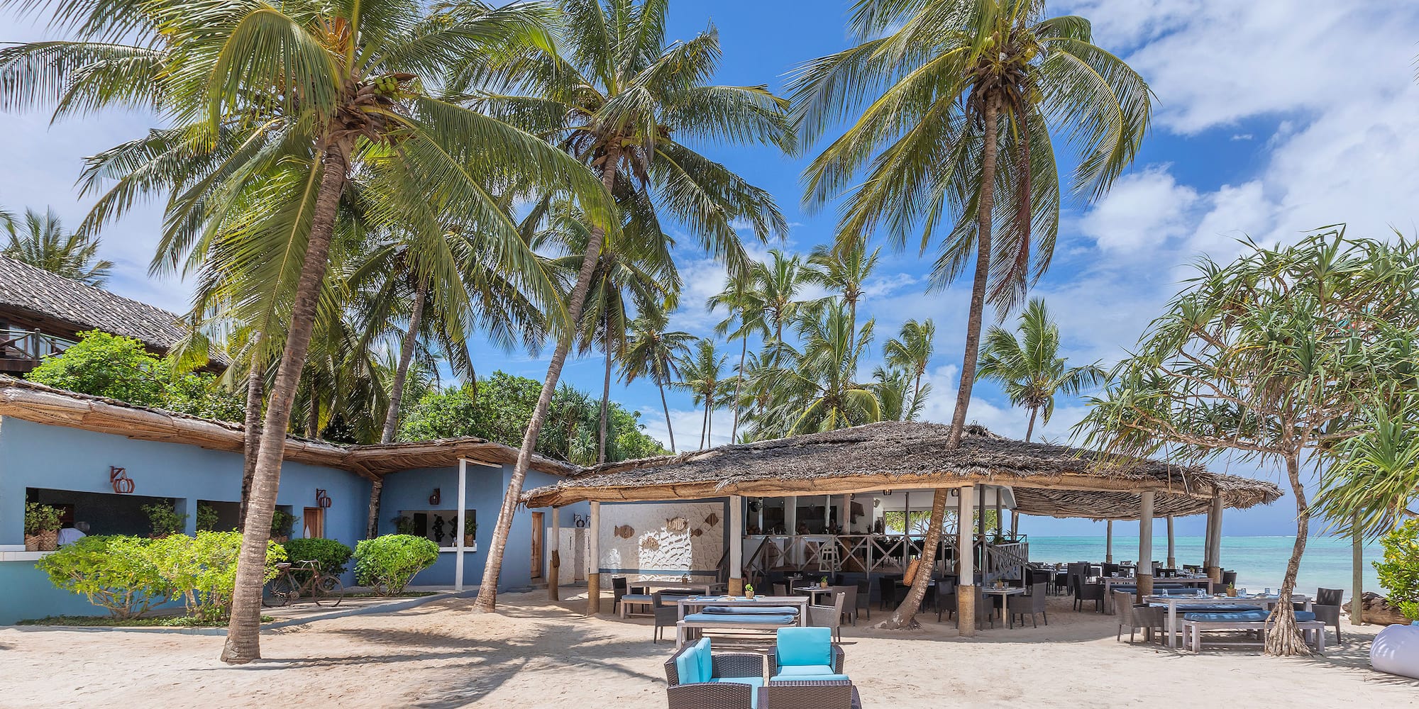 a beach with palm trees and a building