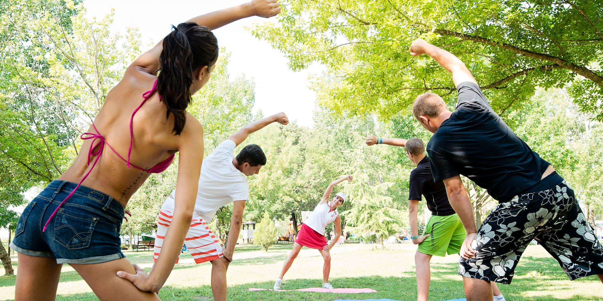a group of people doing yoga in a park