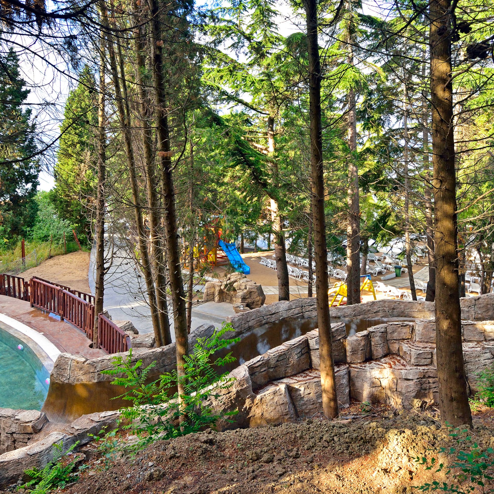 a pool with a slide and trees