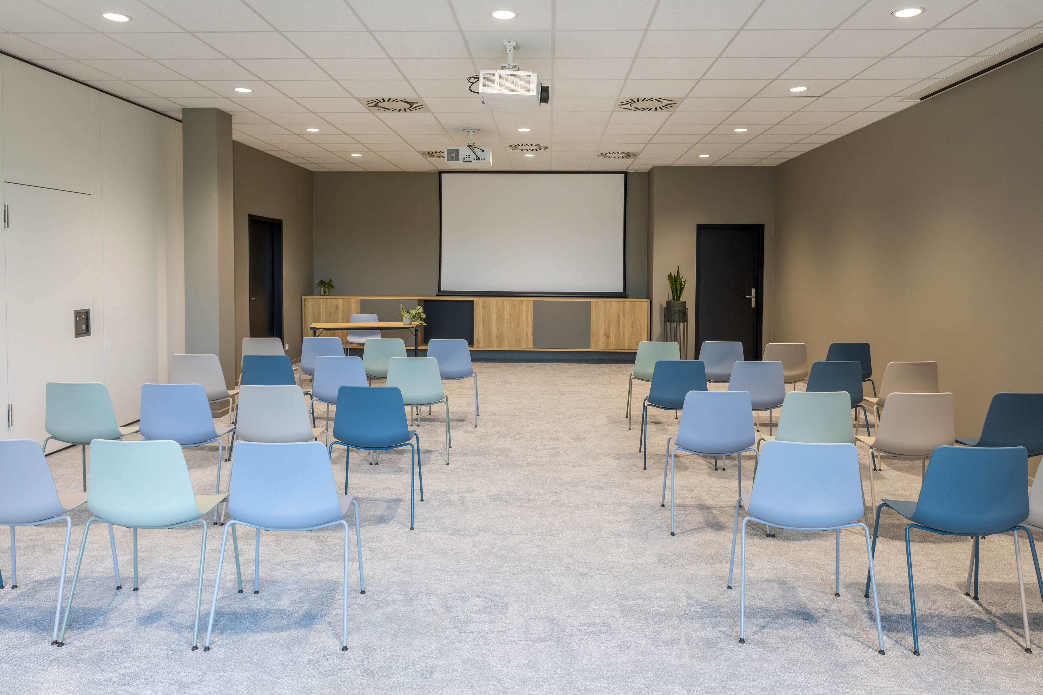a room with chairs and a projector screen