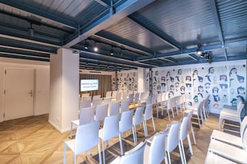 a room with white chairs and a wall with cartoon drawings on the wall