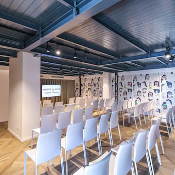 a room with white chairs and a wall with cartoon drawings on the wall