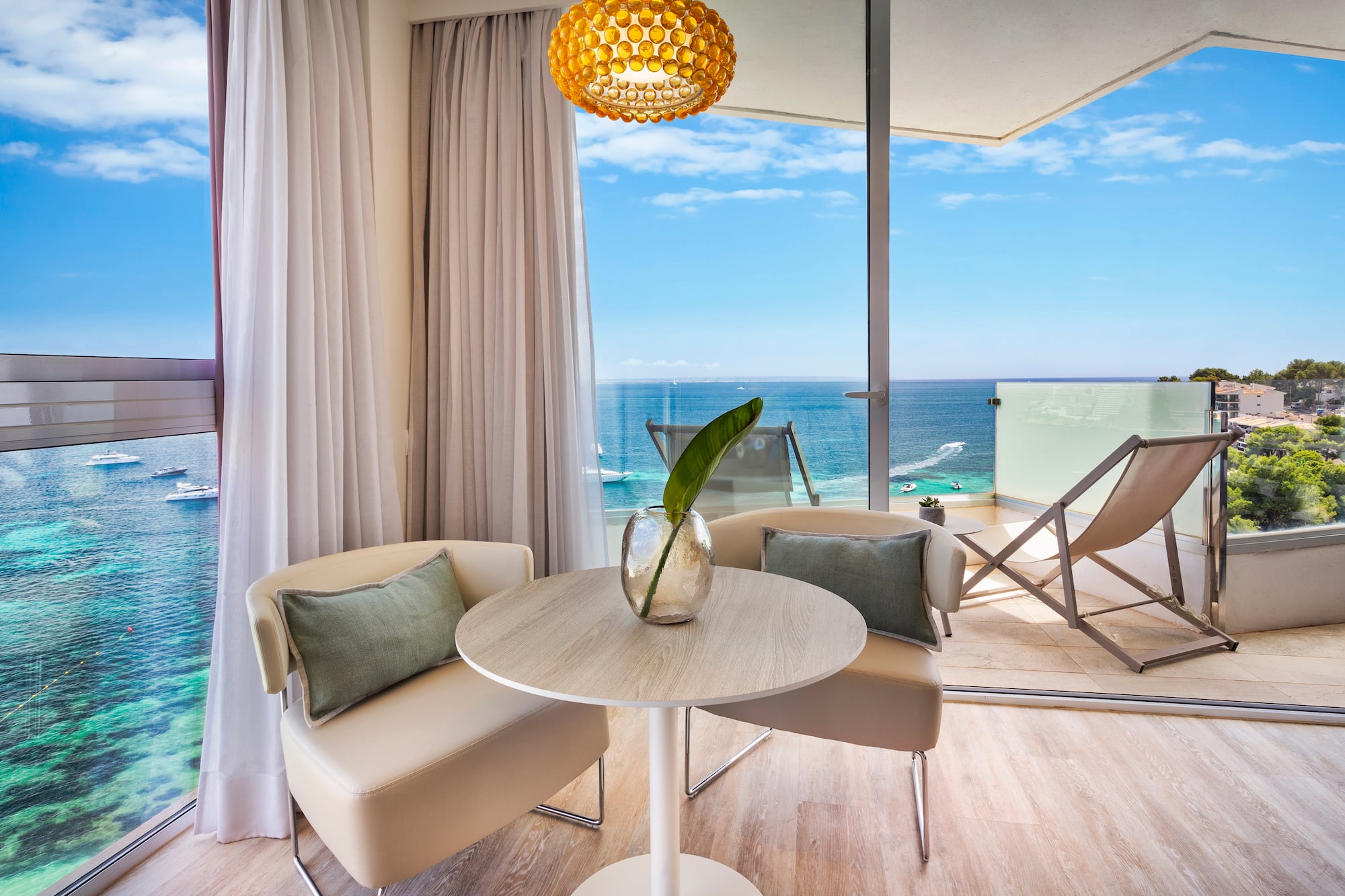 a room with a table and chairs and a view of the ocean