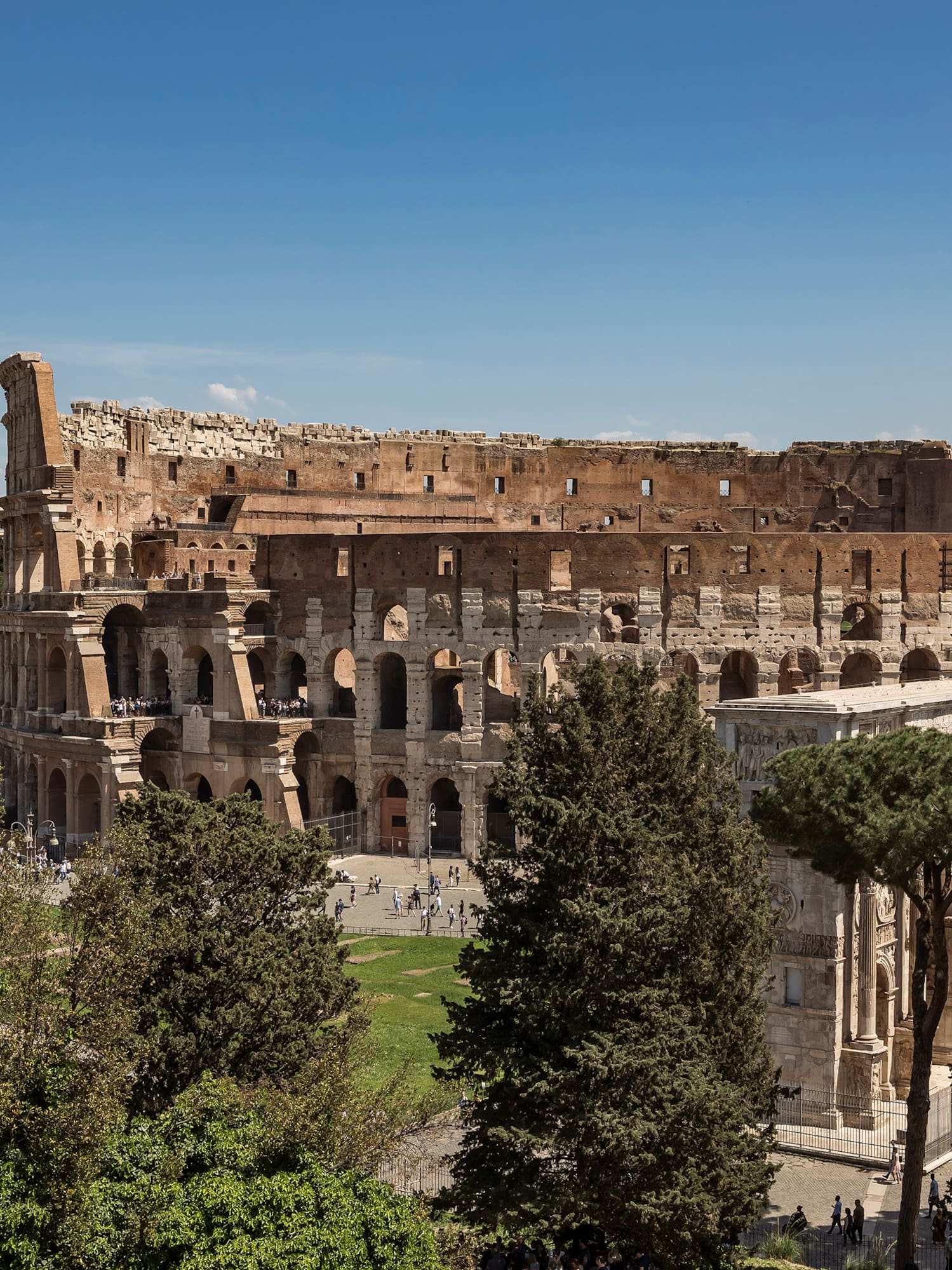 a large stone building with trees and people in the background