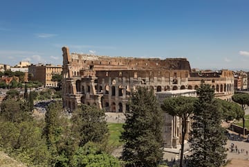 a large stone building with trees and people in the background
