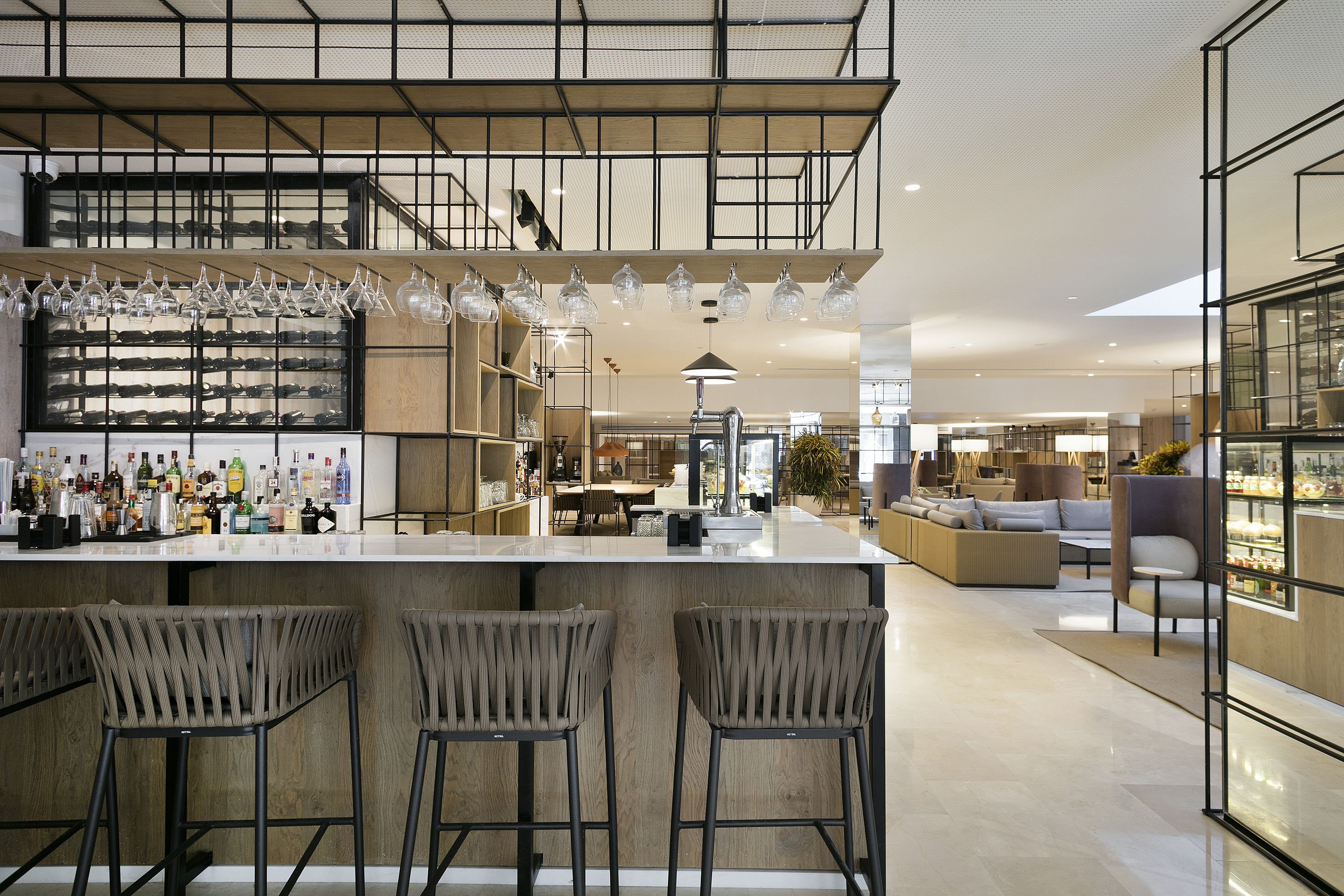 Contemporary hotel bar and lounge with stylish seating and wine display.