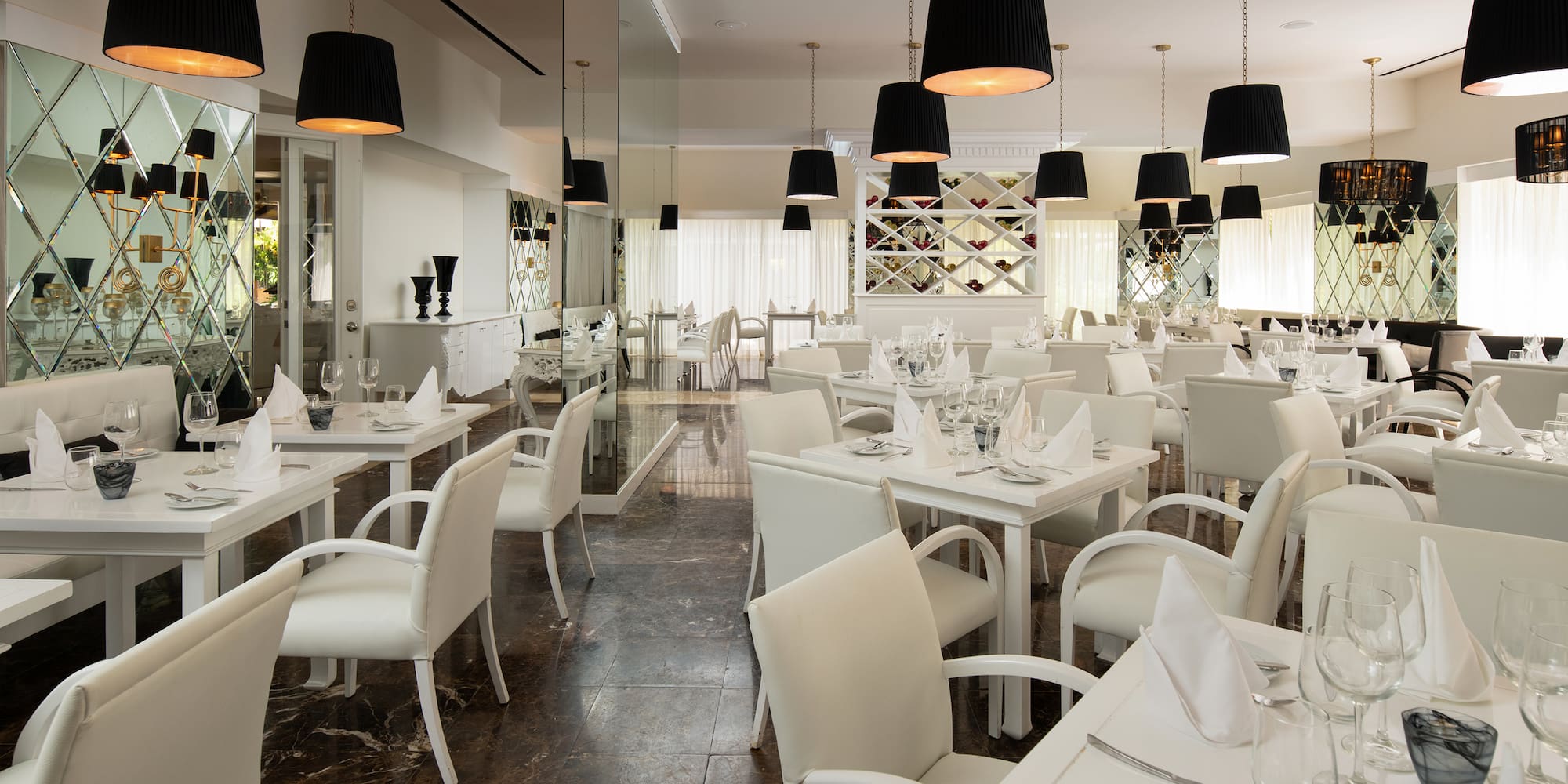 a room with white tables and chairs