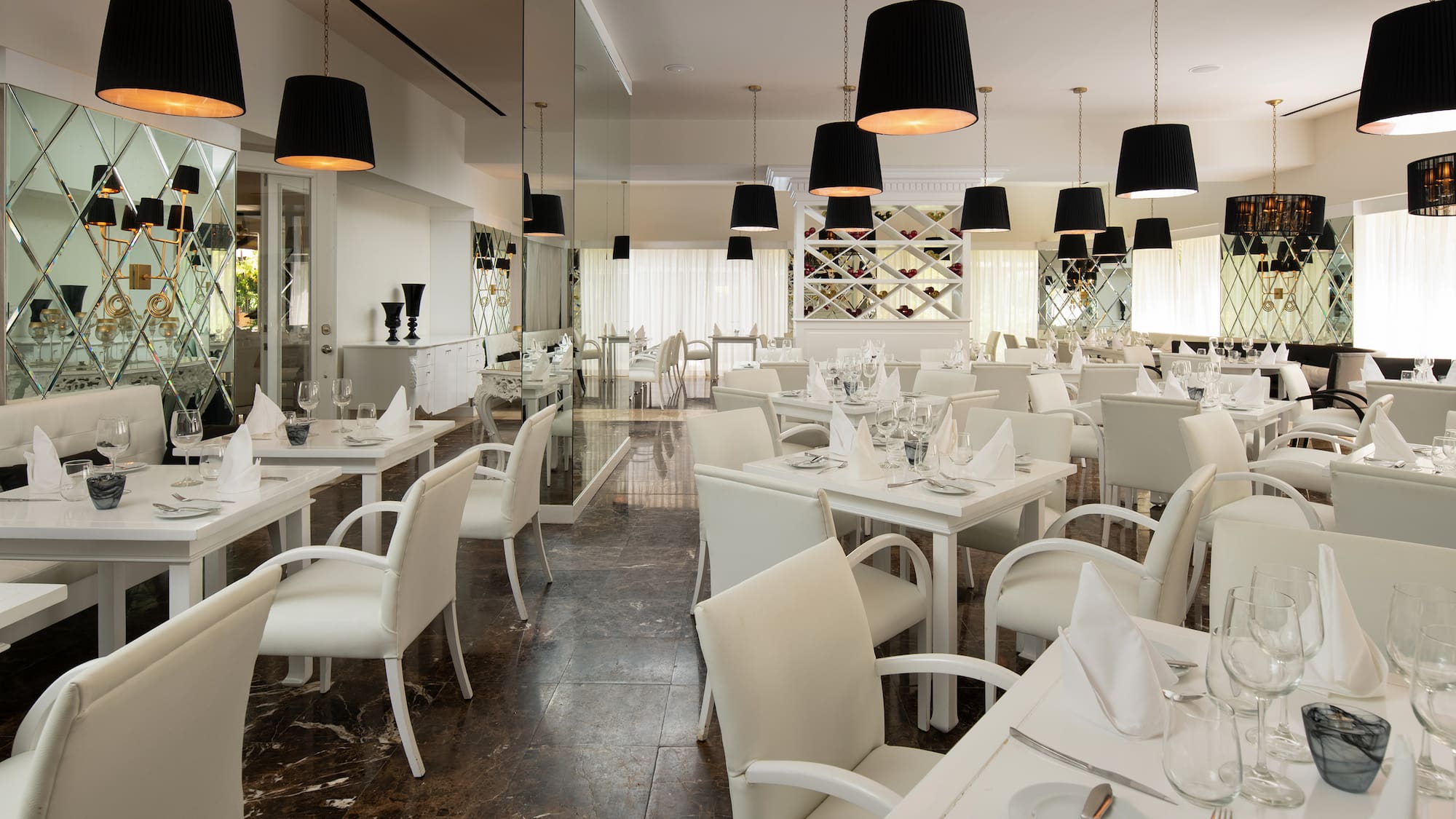 a room with white tables and chairs