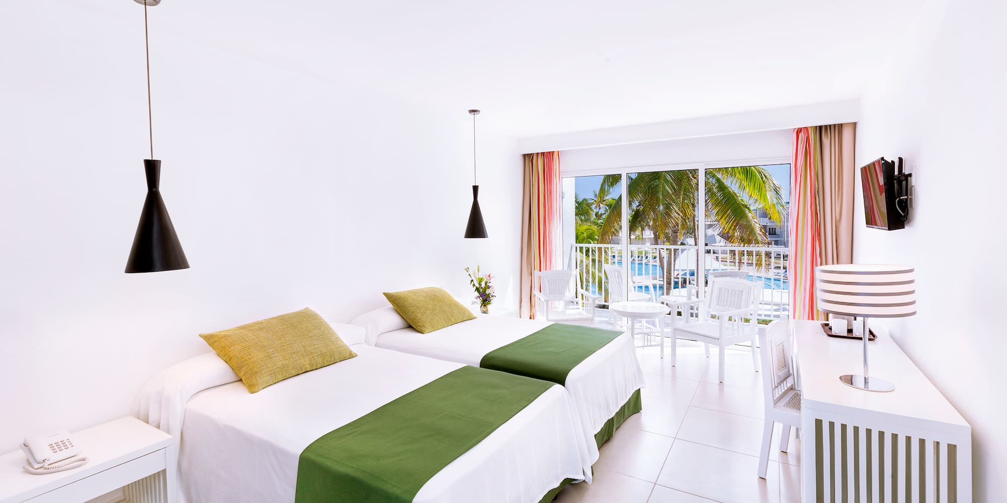 a room with two beds and a table and chairs