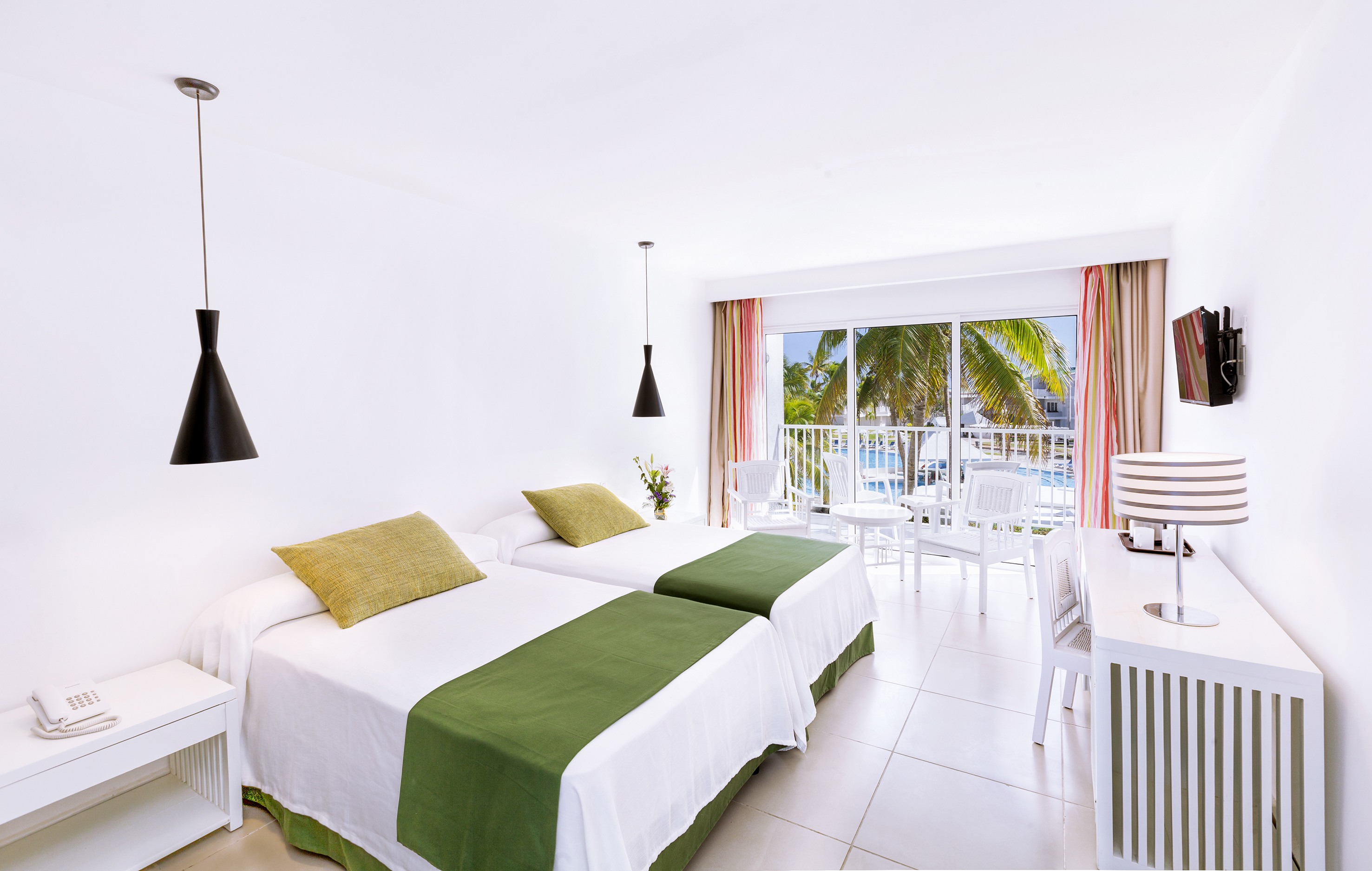 a room with two beds and a table and chairs