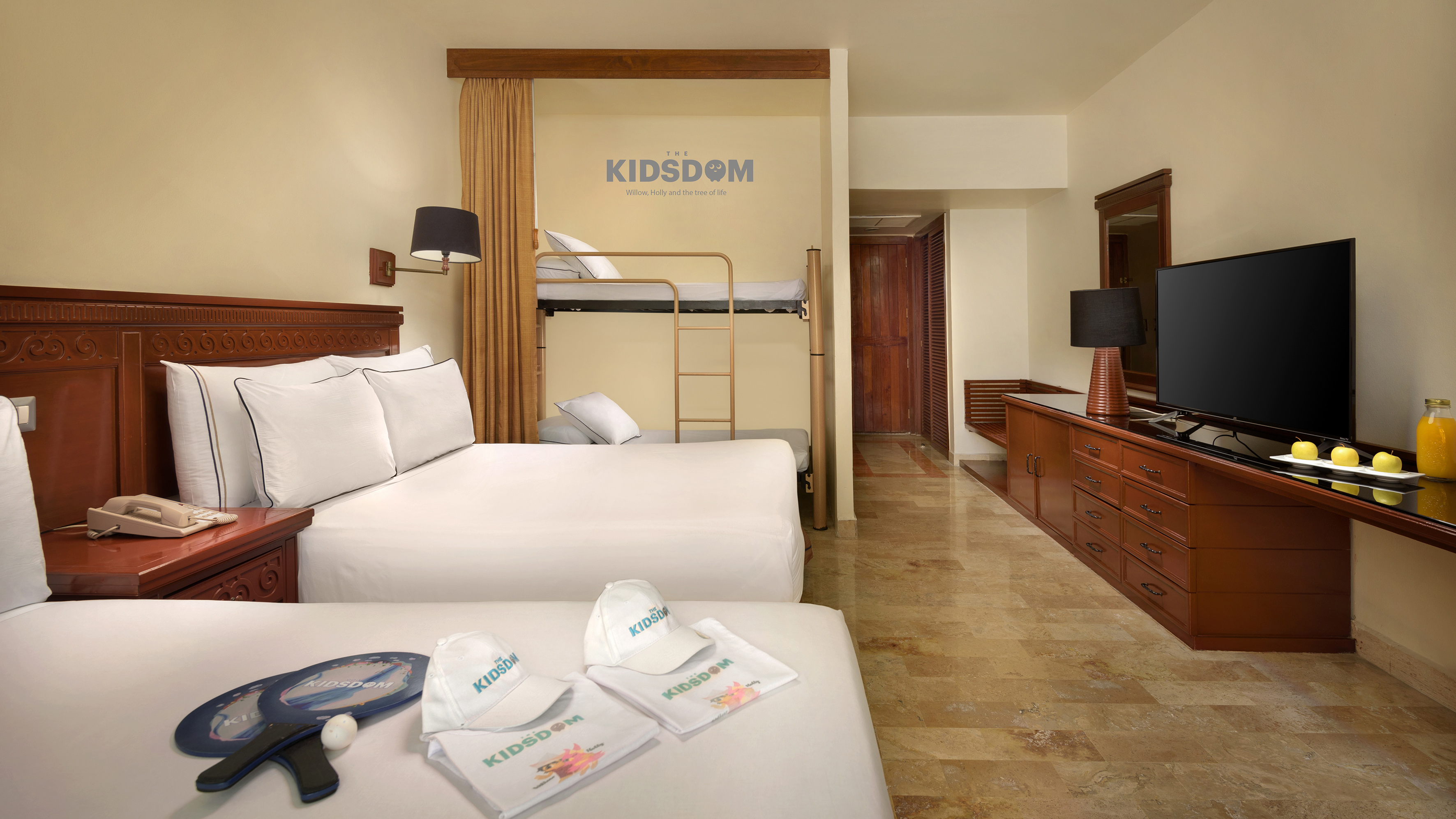 Kidsdom family suite with two beds, bunk beds, TV, and welcoming gifts.
