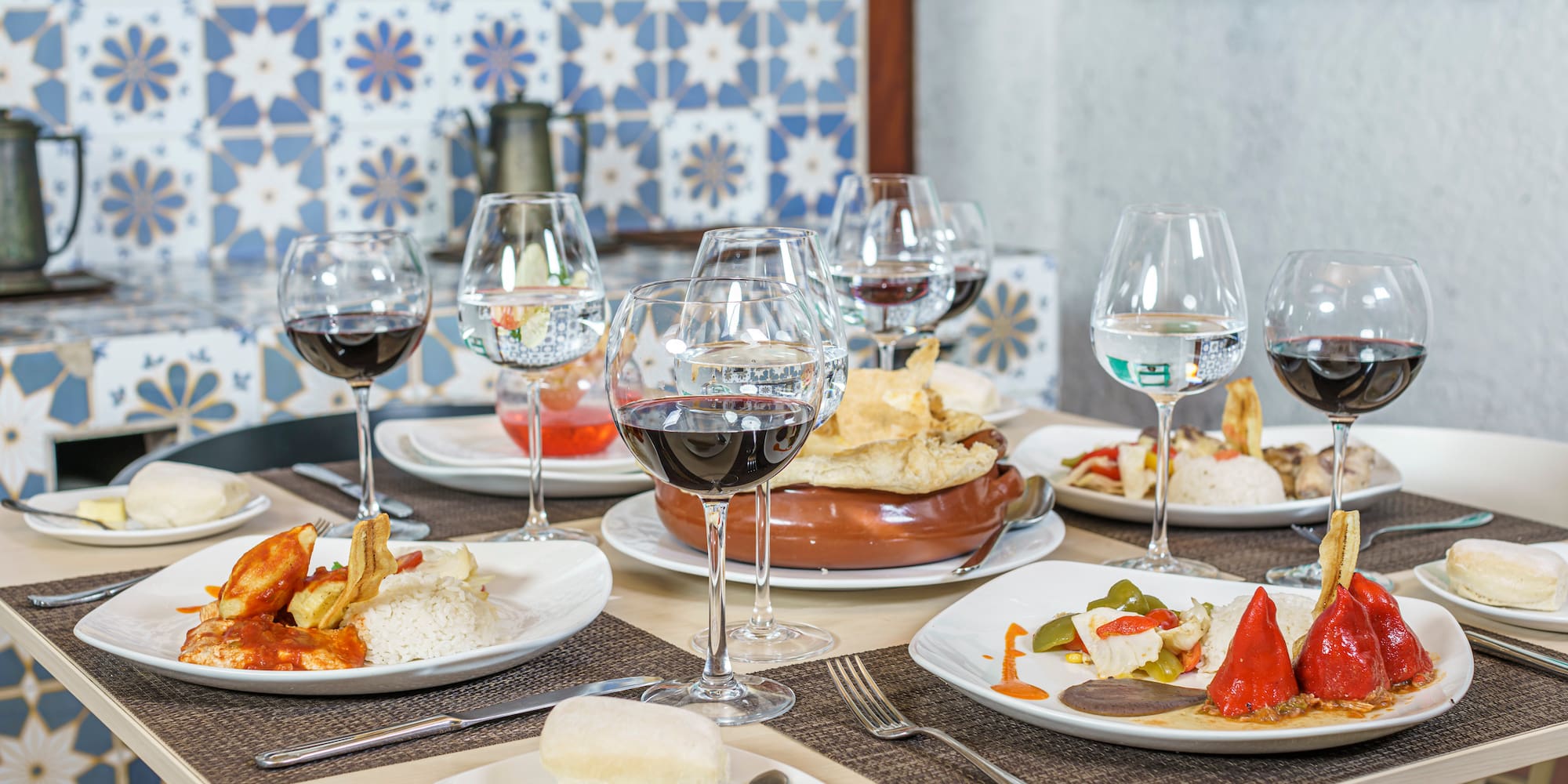 a table with plates of food and wine glasses