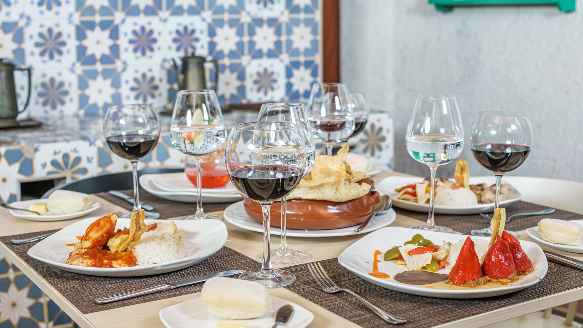 a table with plates of food and wine glasses