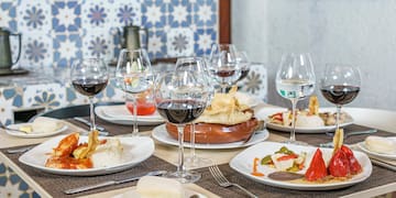 a table with plates of food and wine glasses