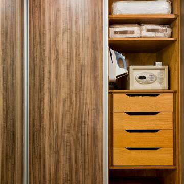 a closet with a microwave and a wood cabinet