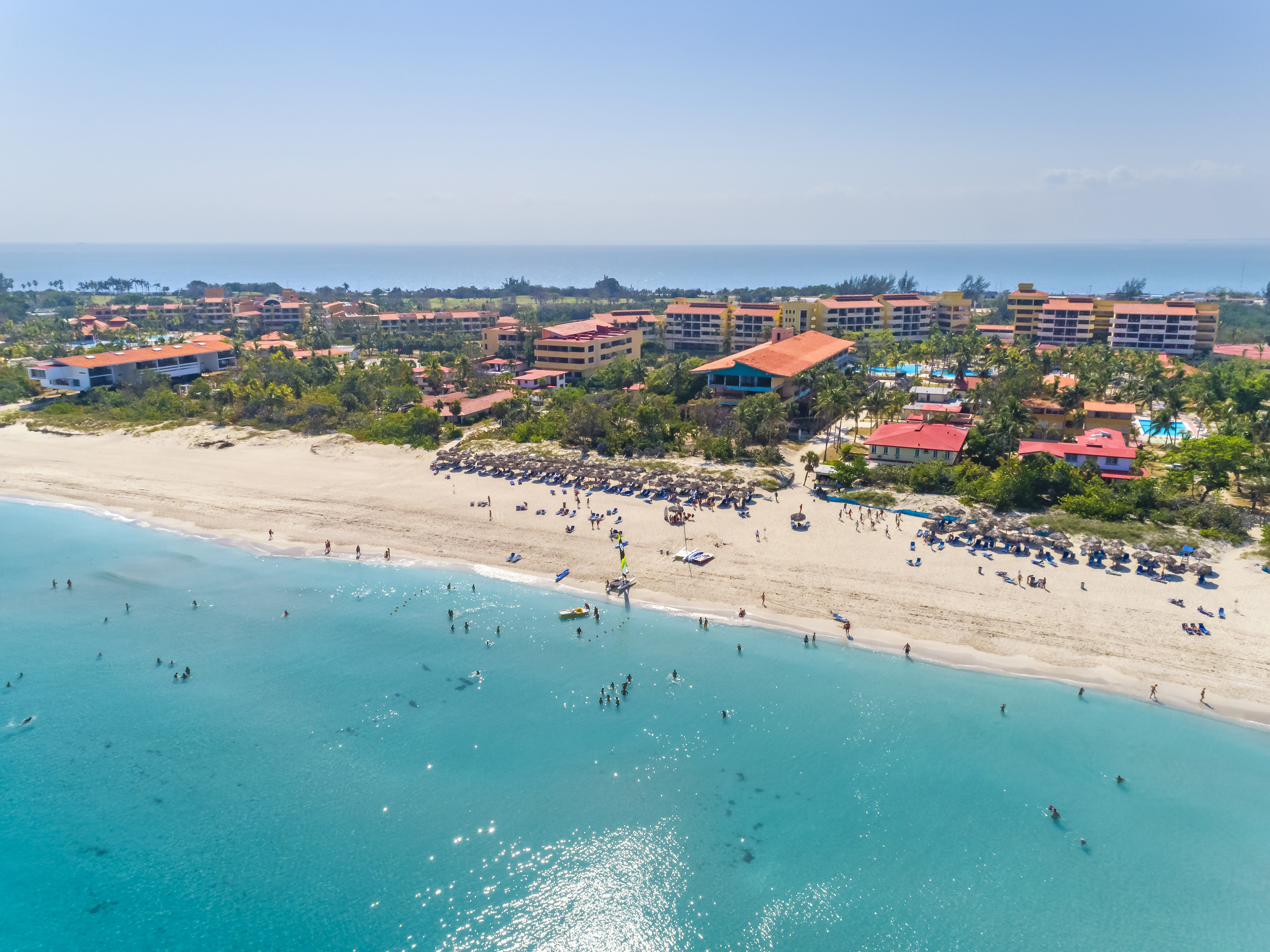 a beach with buildings and blue water