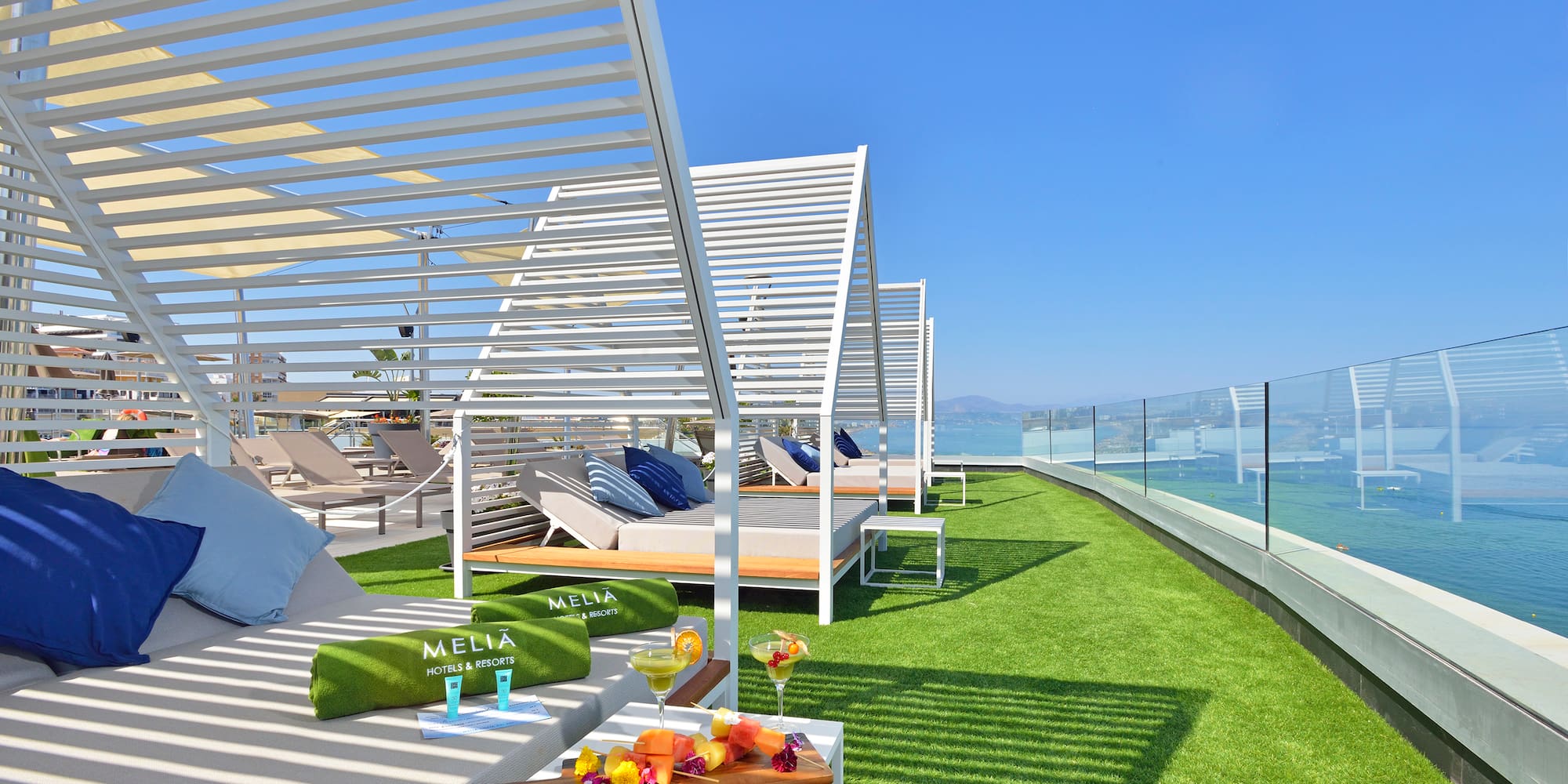 a deck with lounge chairs and a table on a green lawn