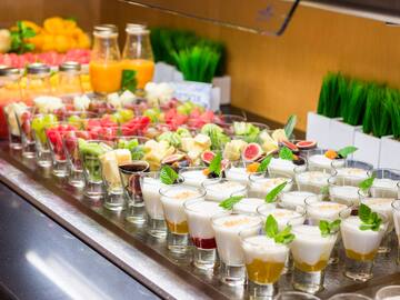 a table full of fruit and yogurt desserts