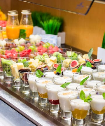 a table full of fruit and yogurt desserts