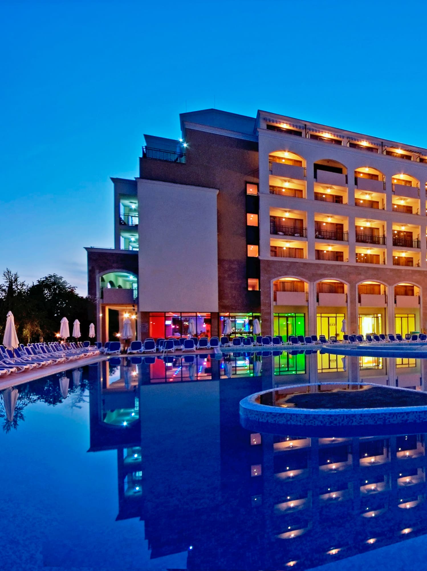 a large building with a pool and a pool in front of it