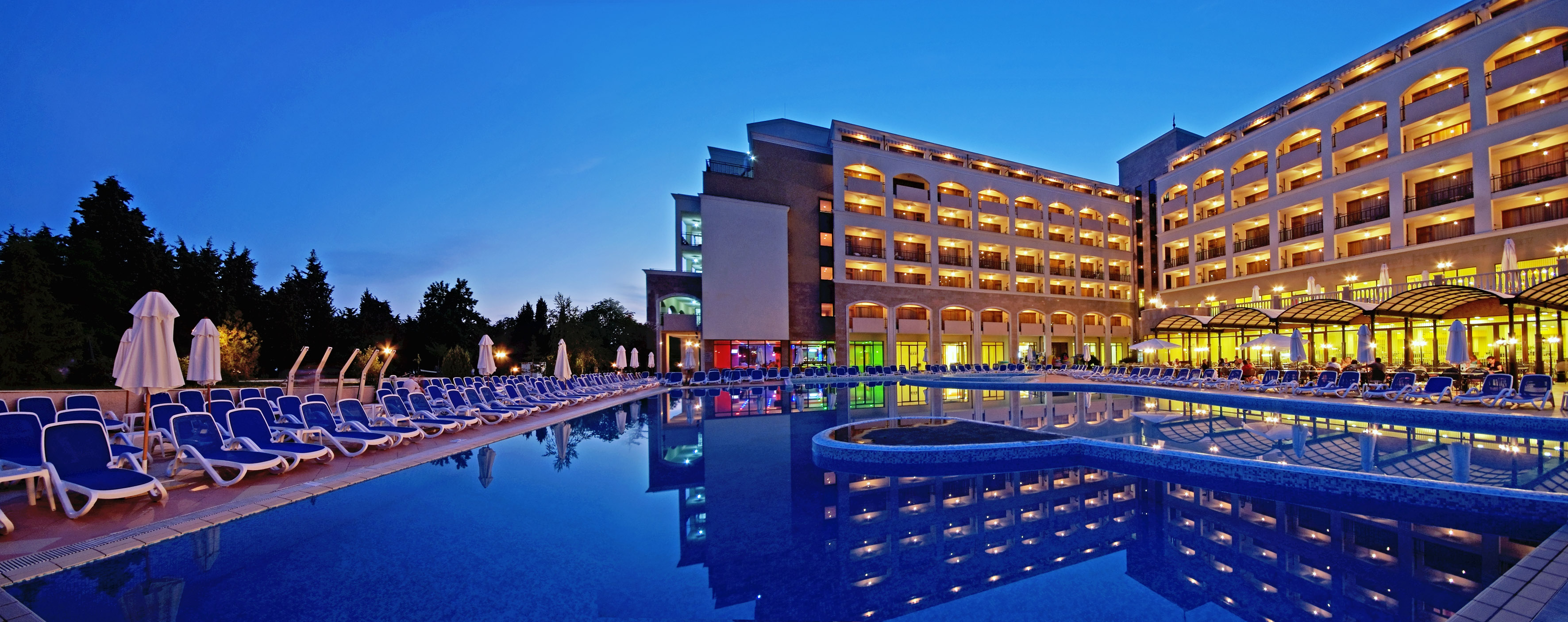 a large building with a pool and a pool in front of it