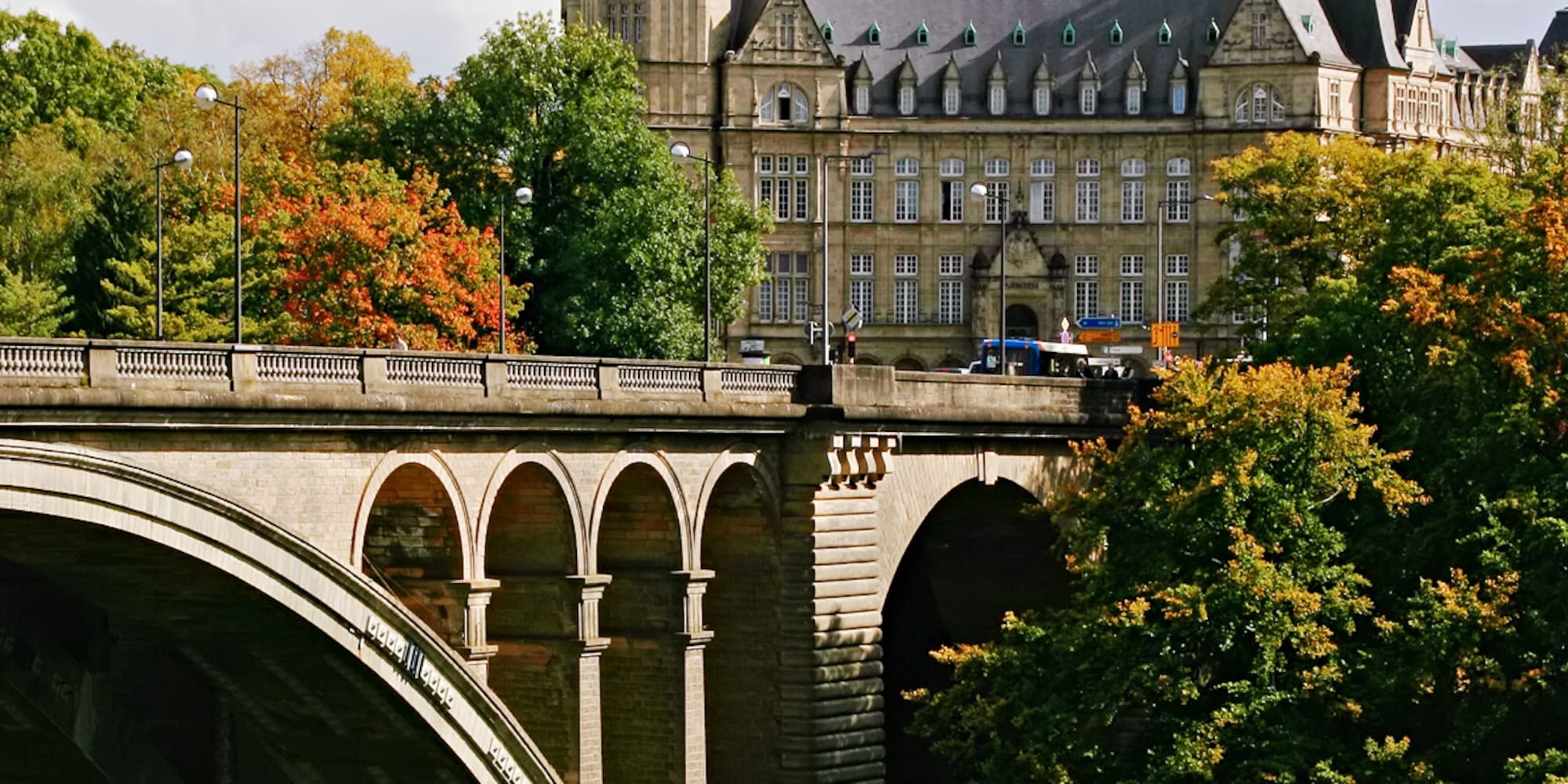 a bridge with trees and a building in the background