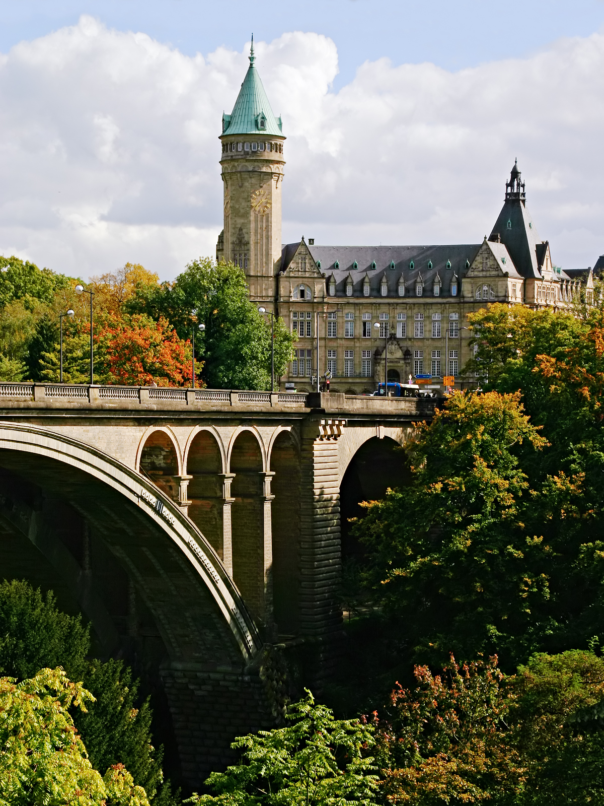 a bridge with trees and a building in the background