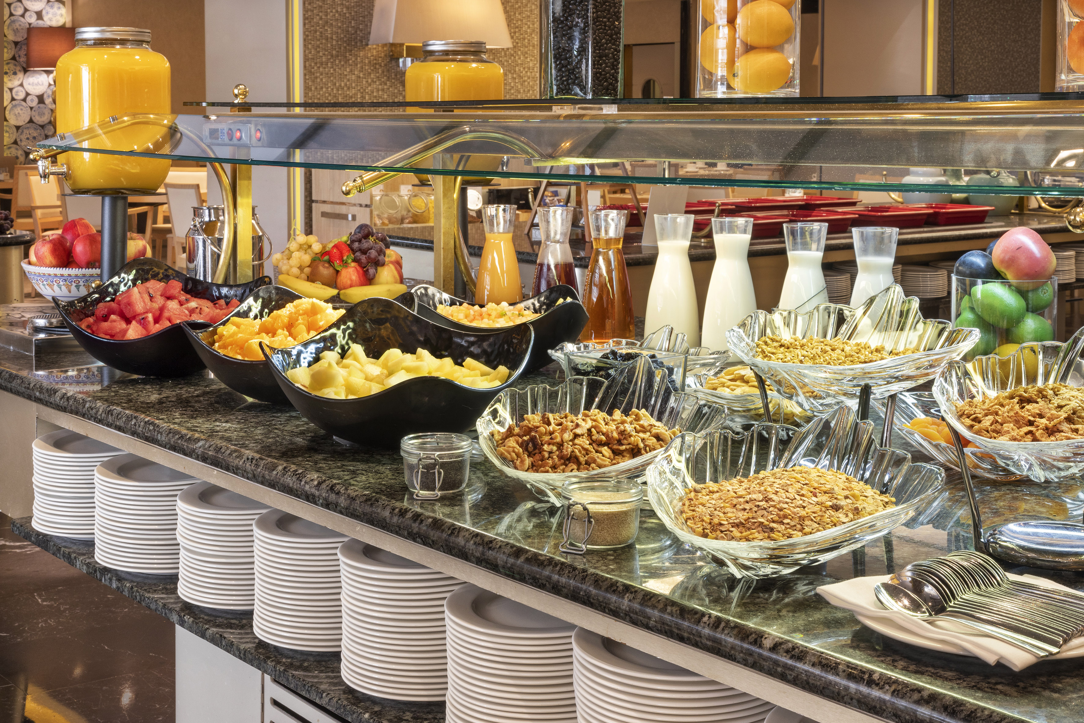Breakfast buffet with fresh fruit, juices, milk, granola, and cereals.