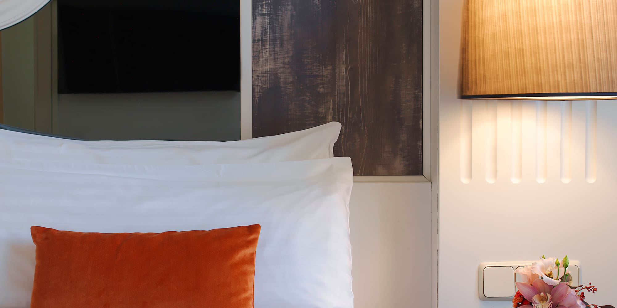 a bed with a vase of flowers on a table