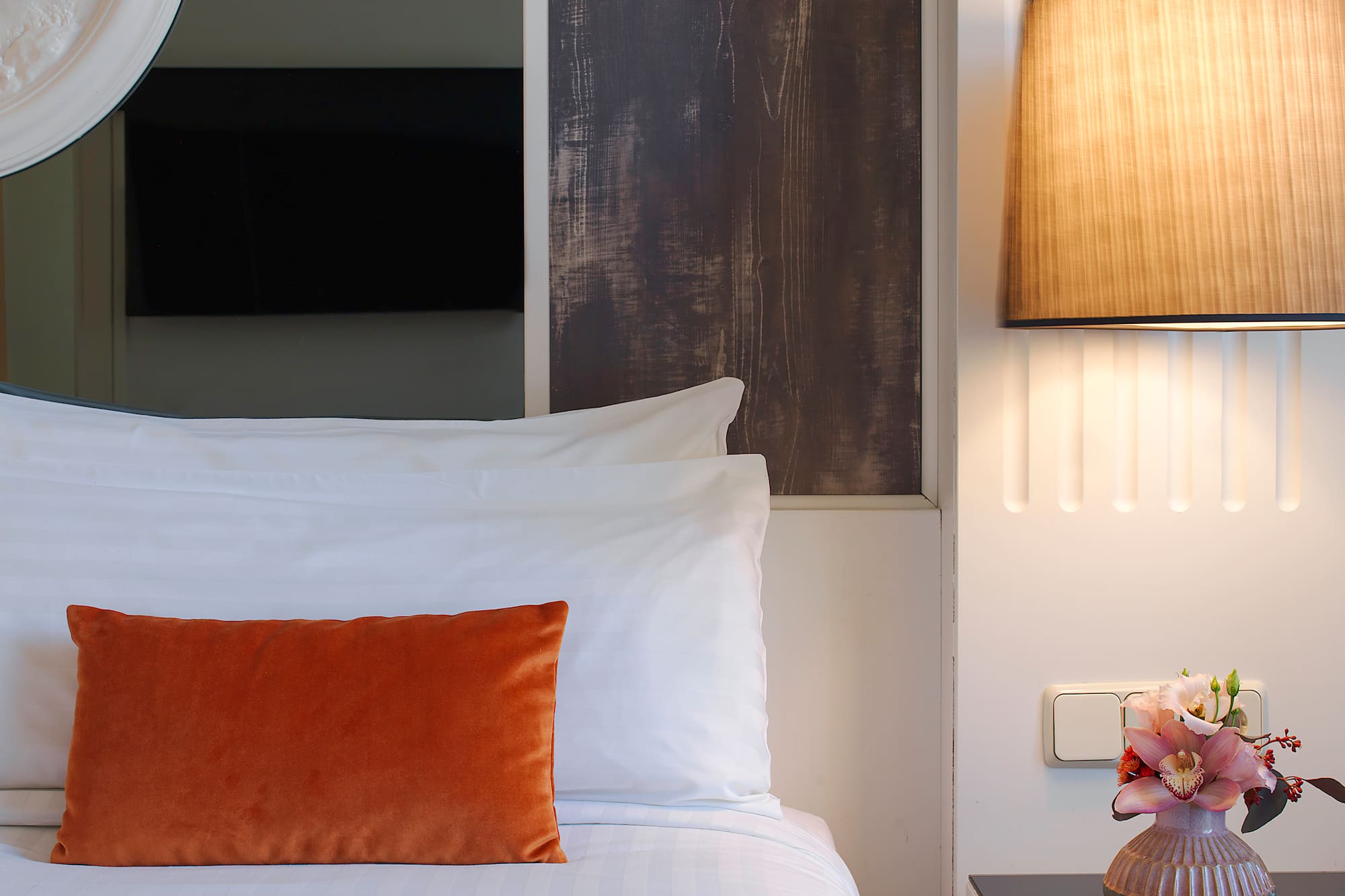 a bed with a vase of flowers on a table