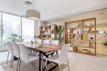 a dining table with chairs in a room with a bookcase