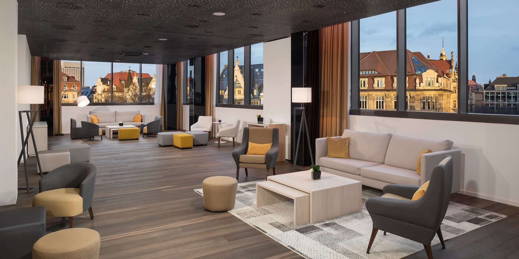 a room with a large window and a couch and chairs