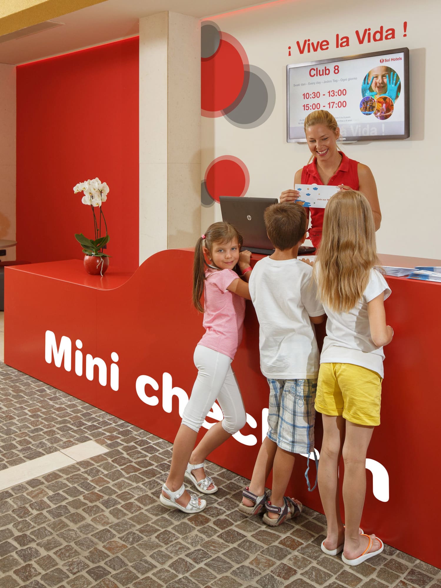 a woman standing next to a group of children
