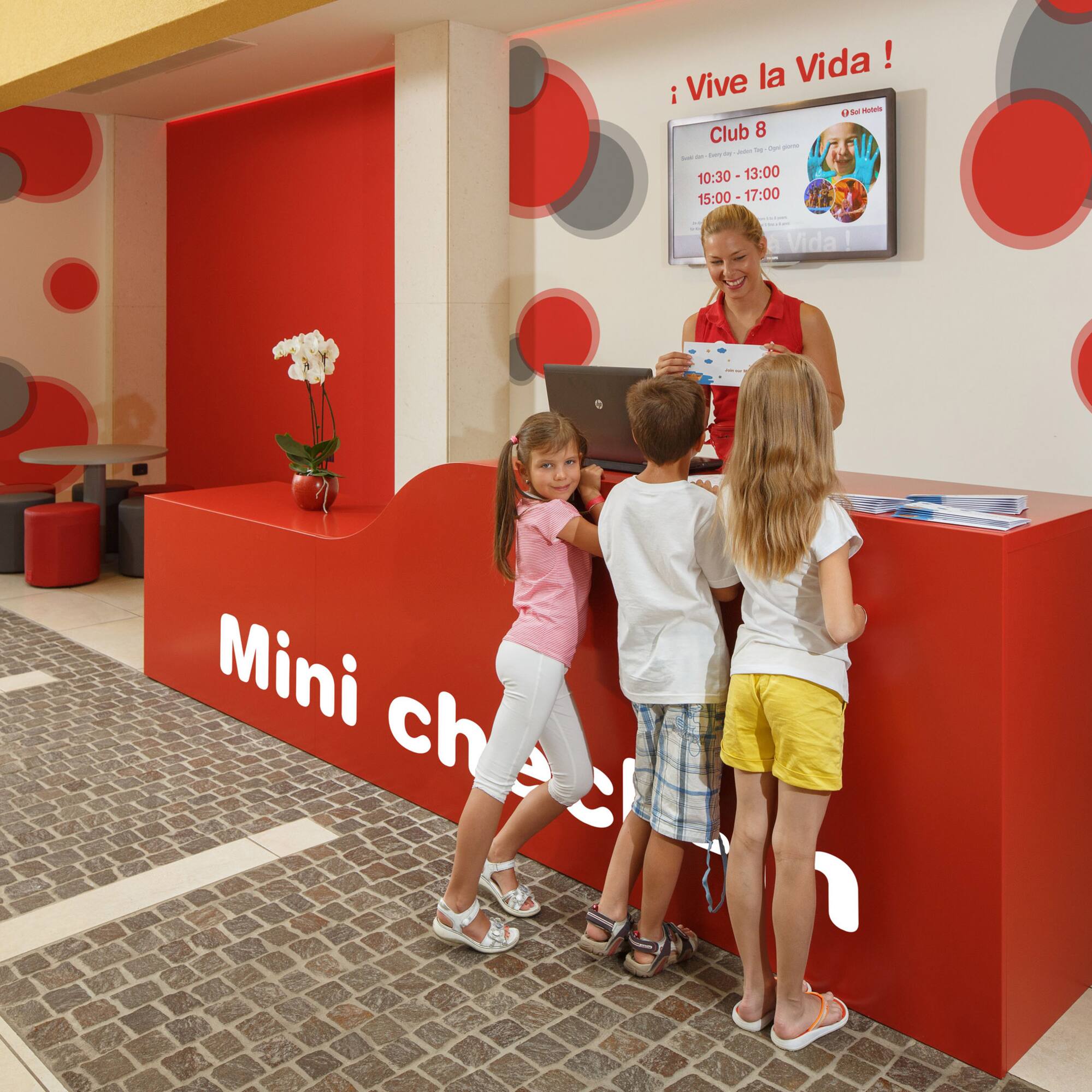 a woman standing next to a group of children