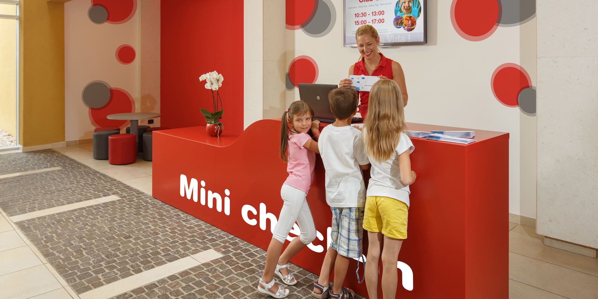 a woman standing next to a group of children