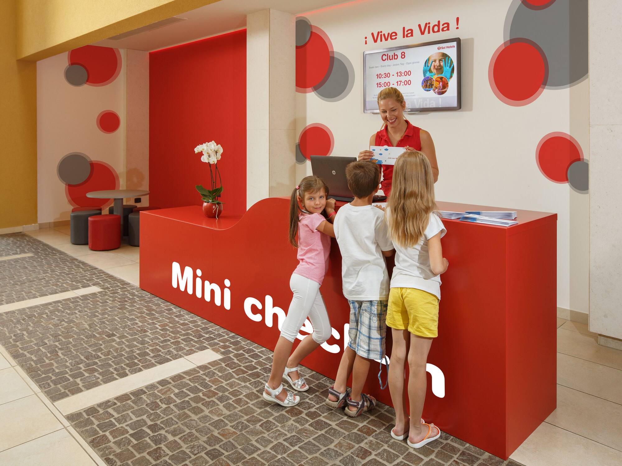 a woman standing next to a group of children