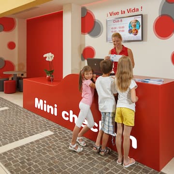 a woman standing next to a group of children