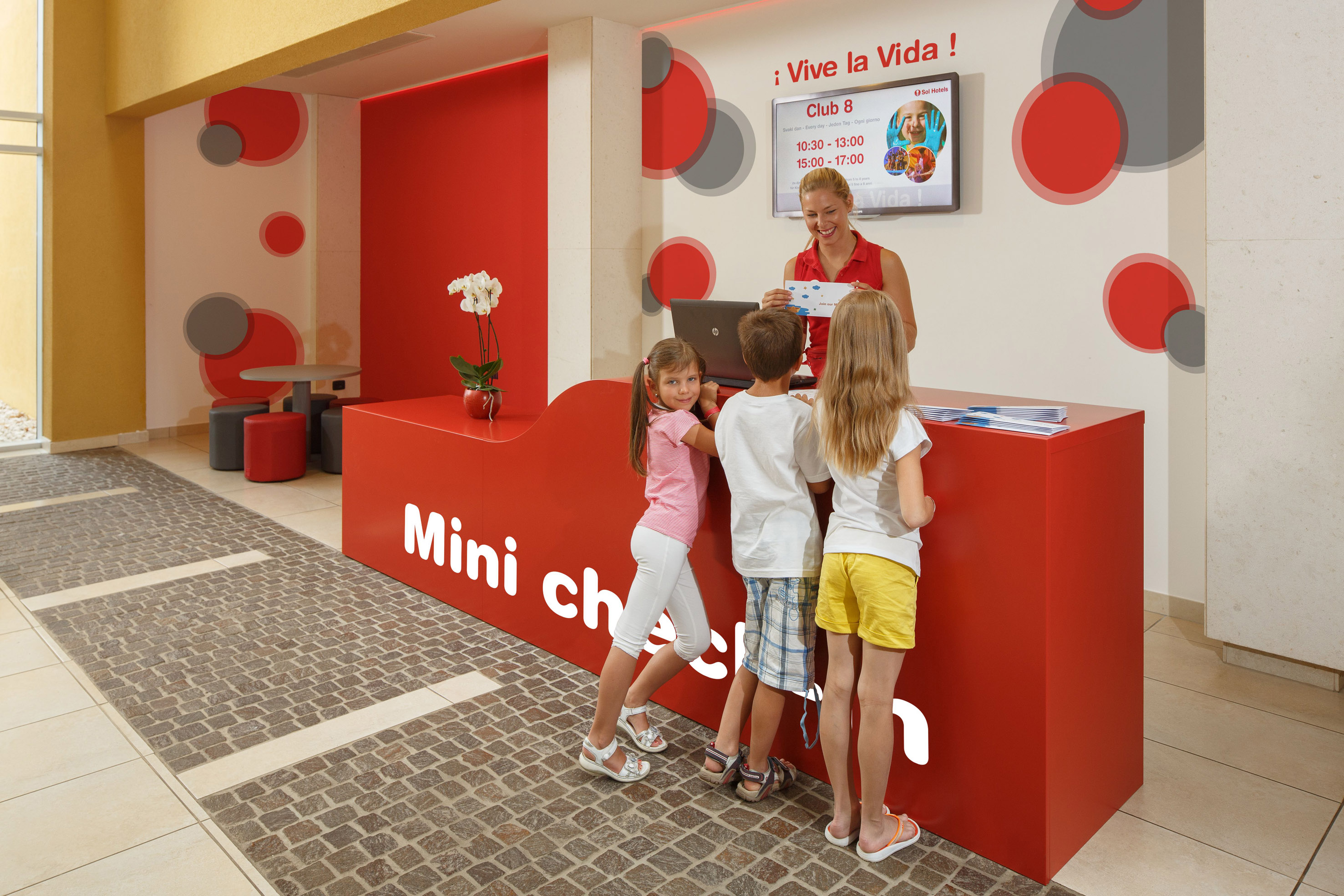 a woman standing next to a group of children