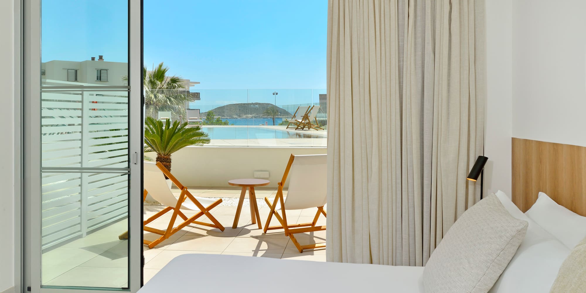 a bed with a table and chairs outside of a room