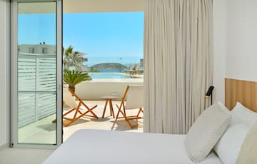 a bed with a table and chairs outside of a room