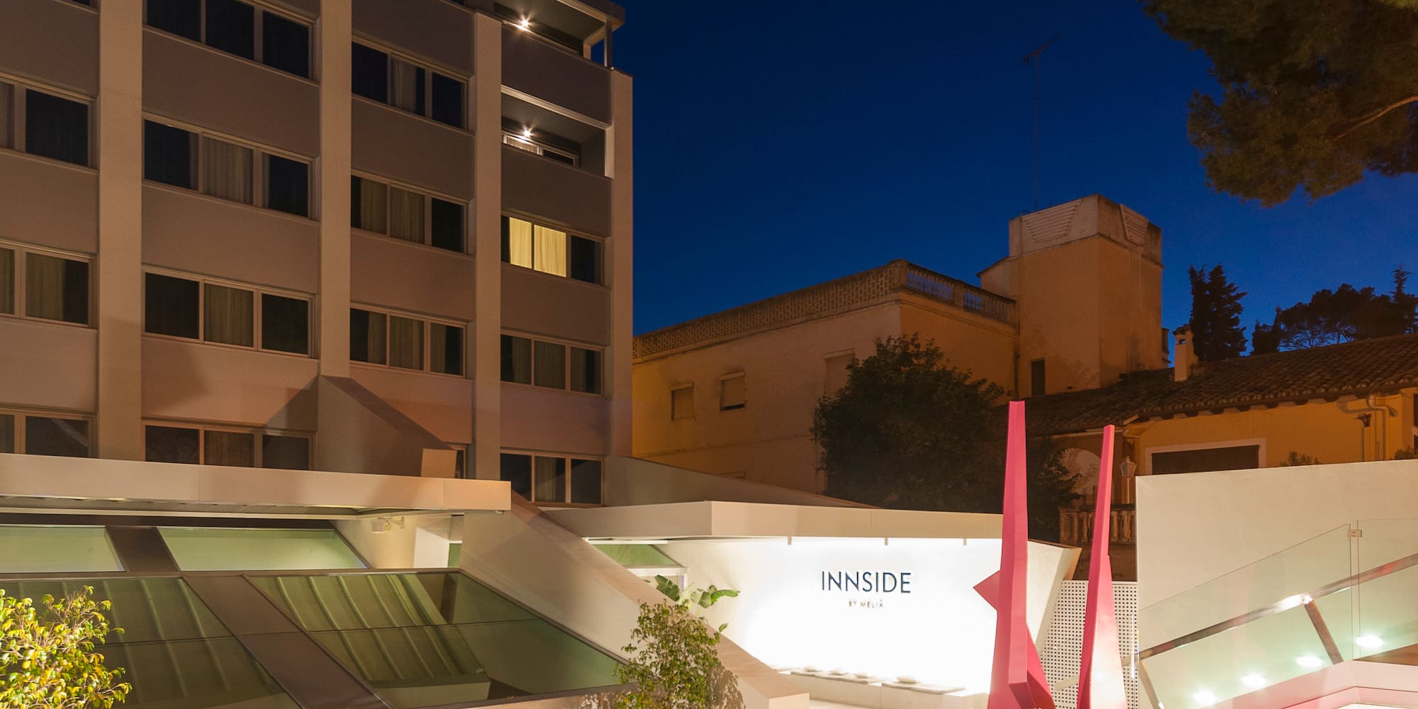 a building with a pink sculpture and bicycles in front of it