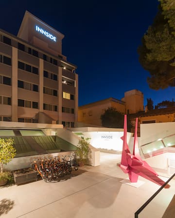 a building with a pink sculpture and bicycles in front of it