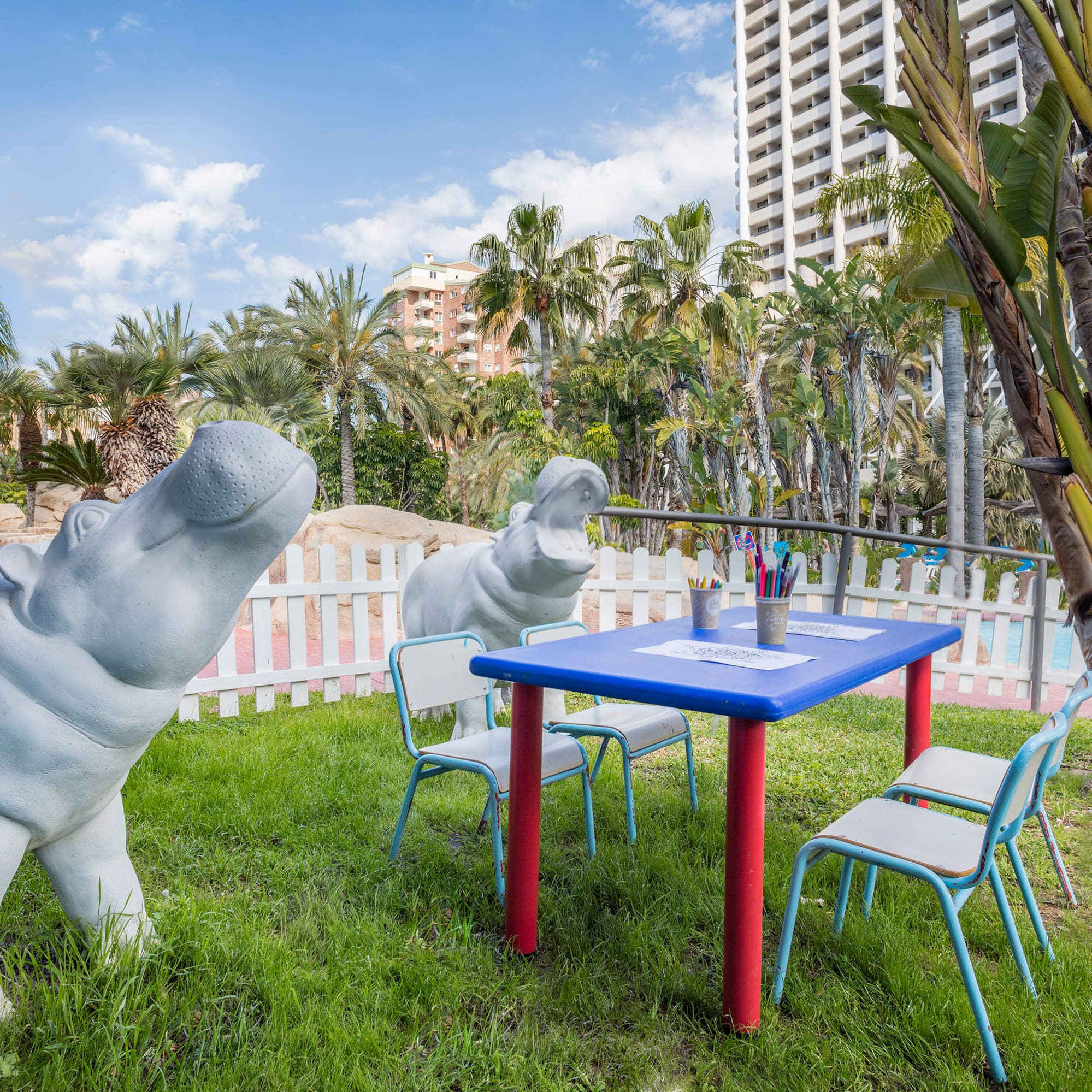 a statue of a hippo next to a table and chairs