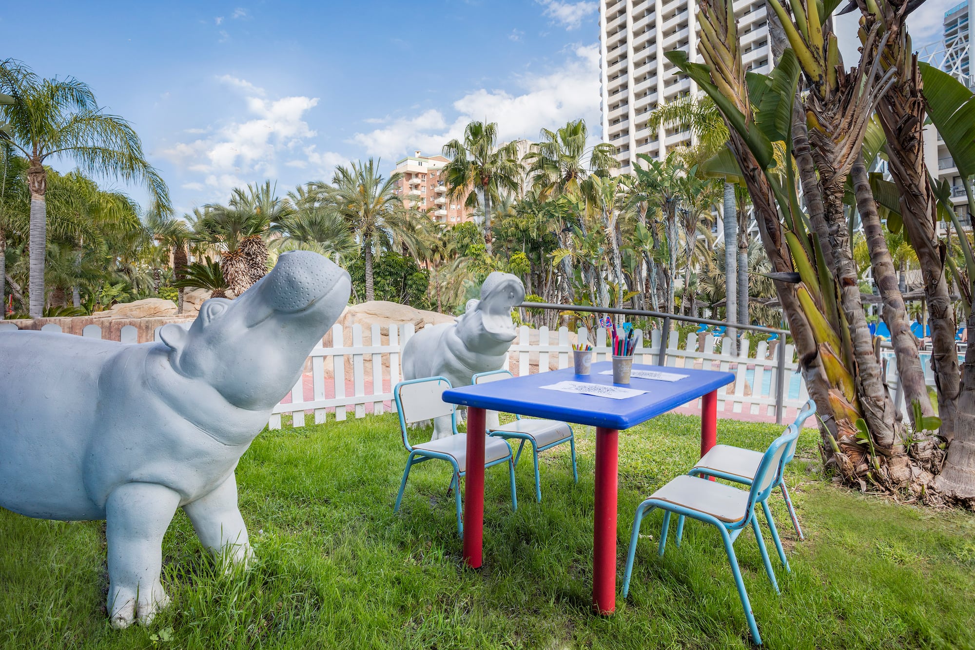 a statue of a hippo next to a table and chairs