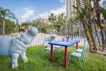 a statue of a hippo next to a table and chairs
