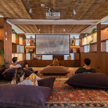 a group of people sitting on pillows in a room with a projector screen