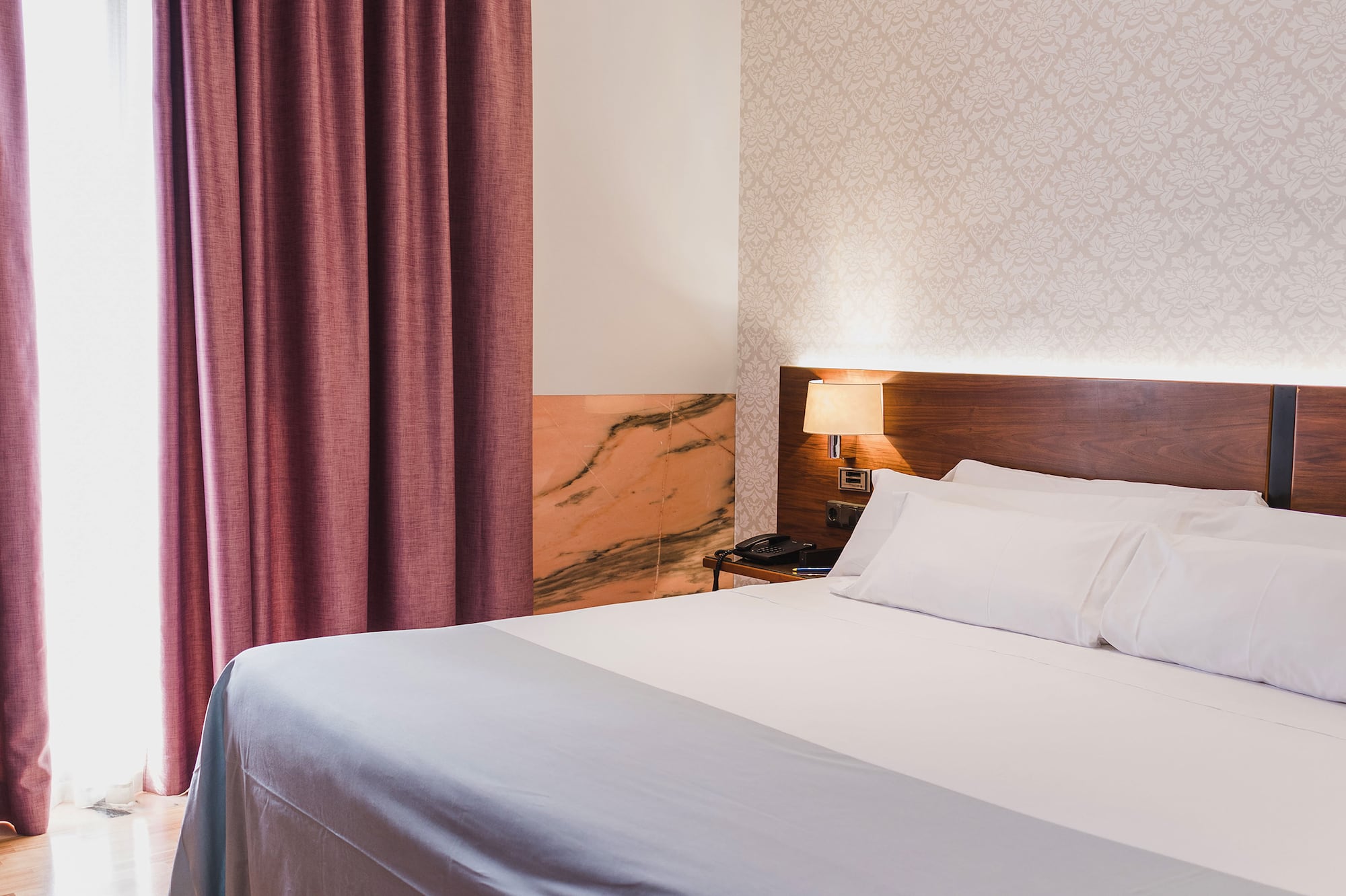 a bed with a lamp and a window