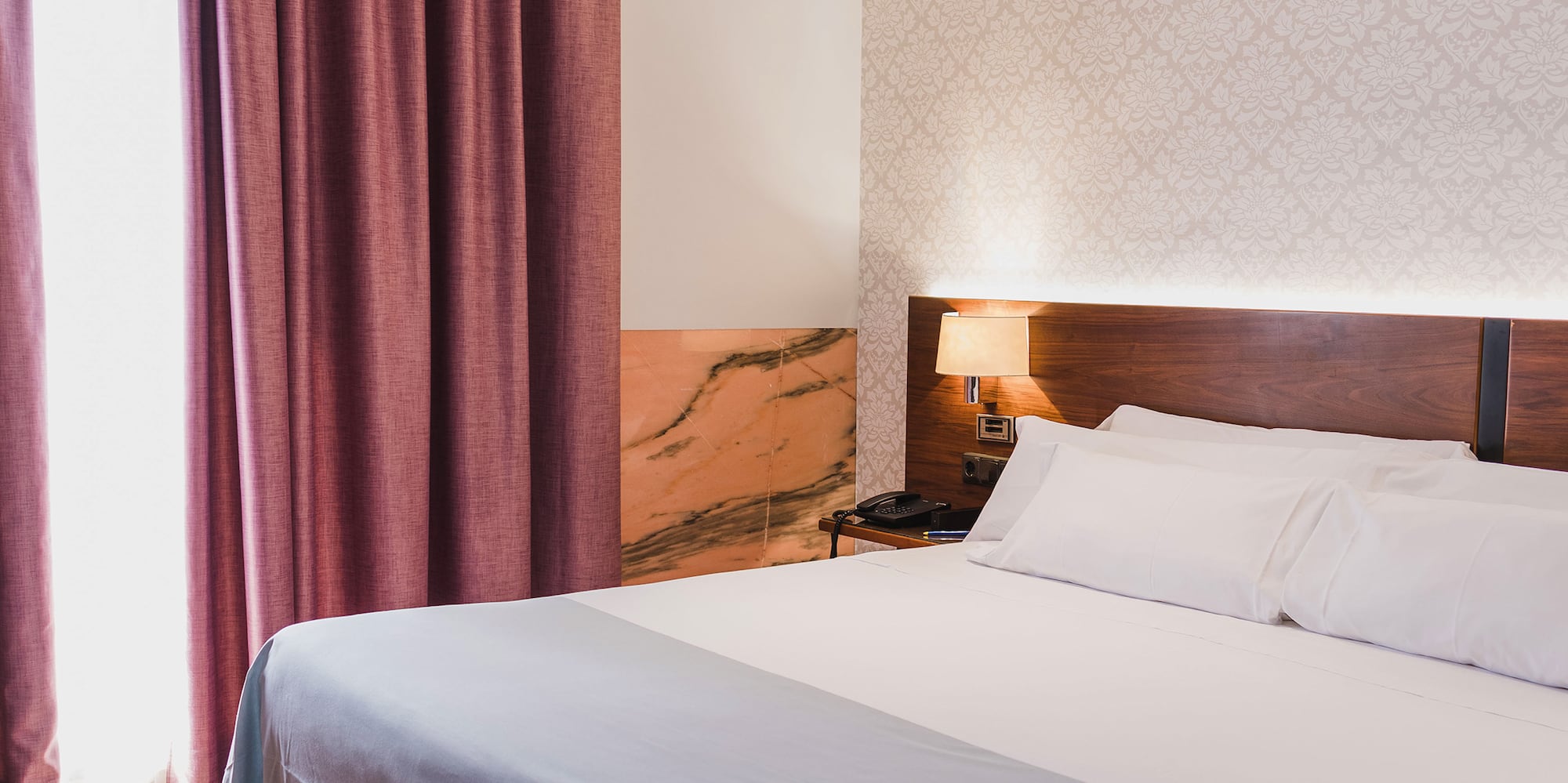 a bed with a lamp and a window