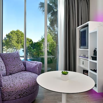 a purple chair and a white table in a room with glass doors
